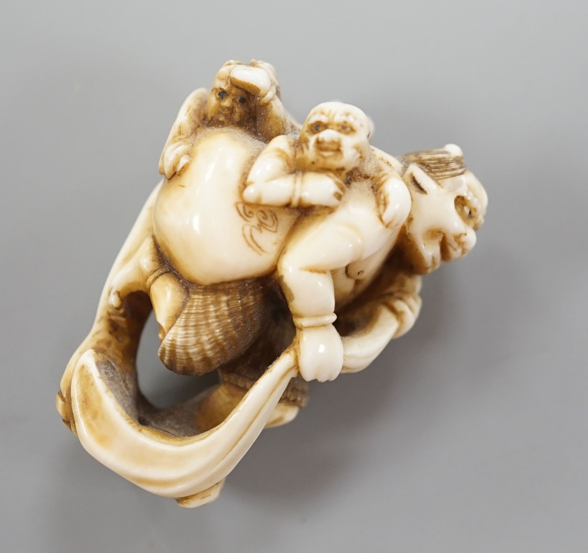 A Japanese ivory netsuke of oni, Meiji period, 4 cms high.